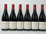 six bouteilles de vin rouge sont alignées sur une table