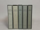 three books sitting on top of each other on a white surface