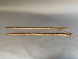 two wooden sticks with a handle are on a gray surface