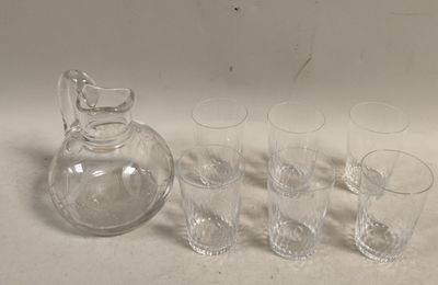 Des bouteilles et des verres sont alignés à côté d'une carafe sur une table