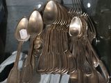 une vitrine contenant de nombreuses cuillères en argent et des cuillères-cuillères