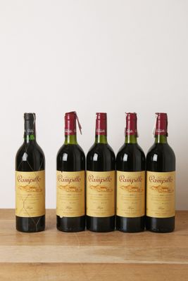 quatre bouteilles de vin sont alignées sur une table en bois