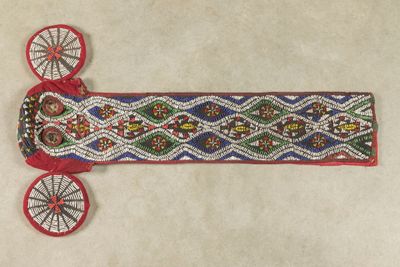 un gros plan d'une ceinture ornée de perles sur un fond blanc