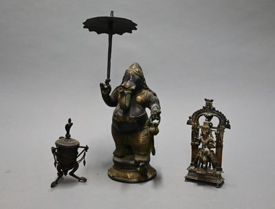 a statue of an elephant holding an umbrella next to other items