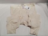 a pair of pants on a bed with a tag on it