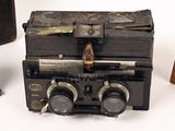 an old fashioned radio sitting on a table next to a suitcase