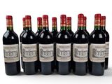 six bottles of red wine lined up in a row on a white surface