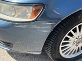 a close up of a car ' s front tire with a cat sitting on it