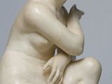 an image of a statue of a woman sitting on top of a rock