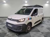 la camionnette blanche est garée dans une pièce au sol en damier