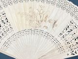 a white fan sitting on top of a table next to a book