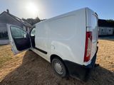 l'arrière d'une camionnette blanche dont la porte est ouverte