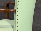 an upholstered chair with a wooden frame and green upholstered upholstered seat