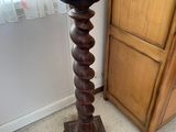 a tall wooden table with a glass top on it