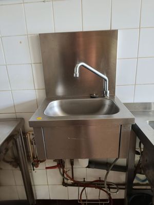 a stainless steel sink in the corner of a kitchen