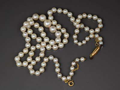 un gros plan d'un collier de perles sur fond noir