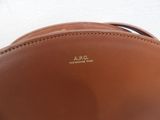 a close up of a brown leather bag on a white surface
