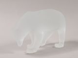 a frosted glass sculpture of a polar bear on a white surface