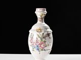 un vase blanc avec des fleurs sur une table