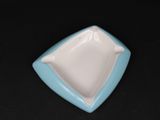 une petite assiette bleue et blanche posée sur une table noire