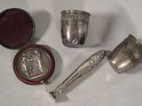 several silver objects are sitting on a white surface next to a red box