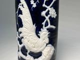 a close up of a vase with a bird on it