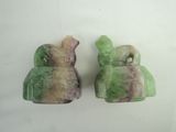pair of green and purple jade figurines on a white surface