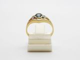 a close up of a gold ring with a blue stone