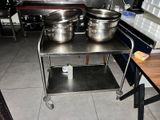 deux grandes casseroles posées sur un chariot en métal dans une cuisine