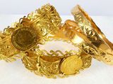 two gold bracelets with a coin on each of them