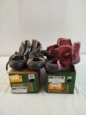 trois paires de chaussures posées sur des cartons, sur une surface blanche