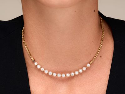 La femme porte un collier orné de perles.