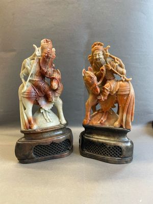 deux figurines représentant un homme et une femme à cheval