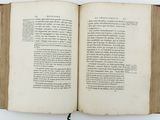 an open book on a white table with a bookmark on it