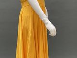 mannequin wearing a yellow dress with a black top and white shoes