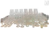des bouteilles et des verres sont alignés en rang sur une surface blanche