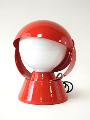 une lampe rouge posée sur une table blanche