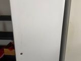 two refrigerators sitting next to each other in a room