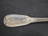 a silver spoon that is sitting on a black surface