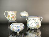 trois types différents de vases en porcelaine posés sur une table avec un miroir