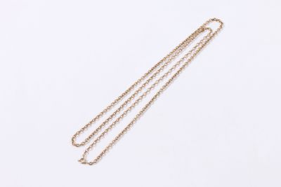 gros plan d'un collier en or avec une chaîne sur fond blanc