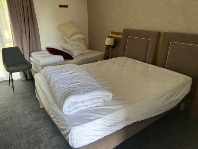 deux lits dans une chambre d'hôtel, recouverts de draps blancs