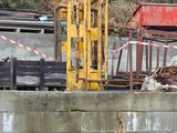 a construction worker that is standing next to a pile of wood