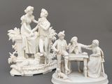 deux figurines blanches représentant des personnes assises à une table