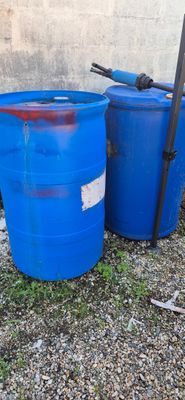 two blue barrels sitting next to each other on the ground