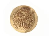an old gold coin on a white surface with a bird on it