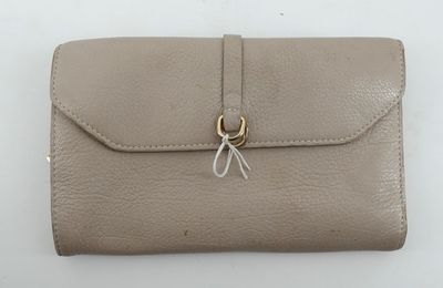 une photo d'un portefeuille en cuir beige muni d'un fermoir métallique