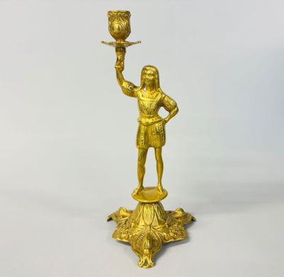 brass figurine of a man holding a bird on a pedestal