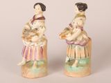 pair of ceramic figurines of a woman and a child with a basket