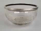 un bol en verre bordé d'argent posé sur une table